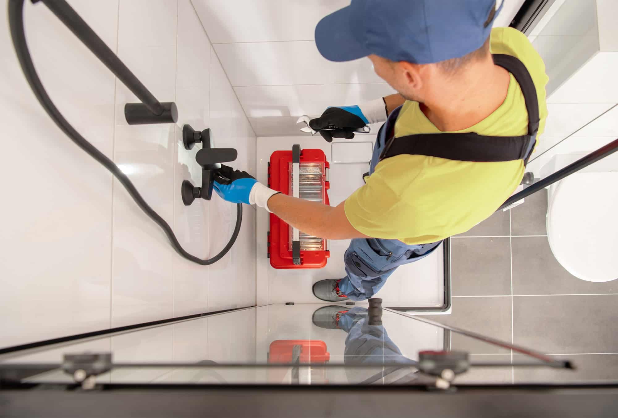 Professional plumber working on bathroom pipes