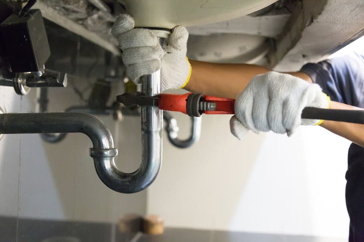 Plumber repairing a toilet cistern flush mechanism
